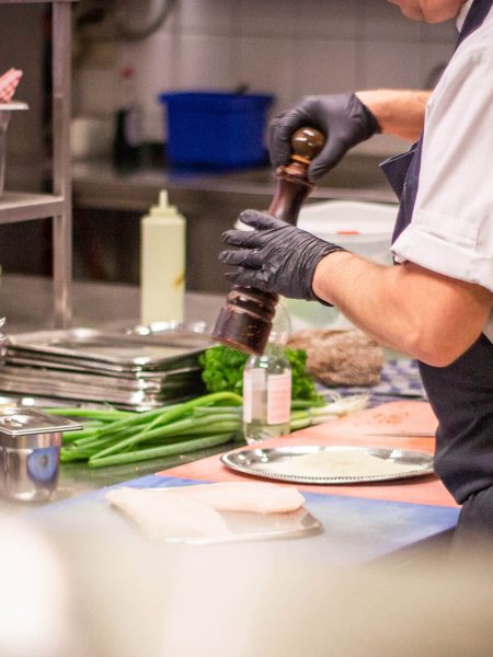 Image of someone adding salt to chicken breasts